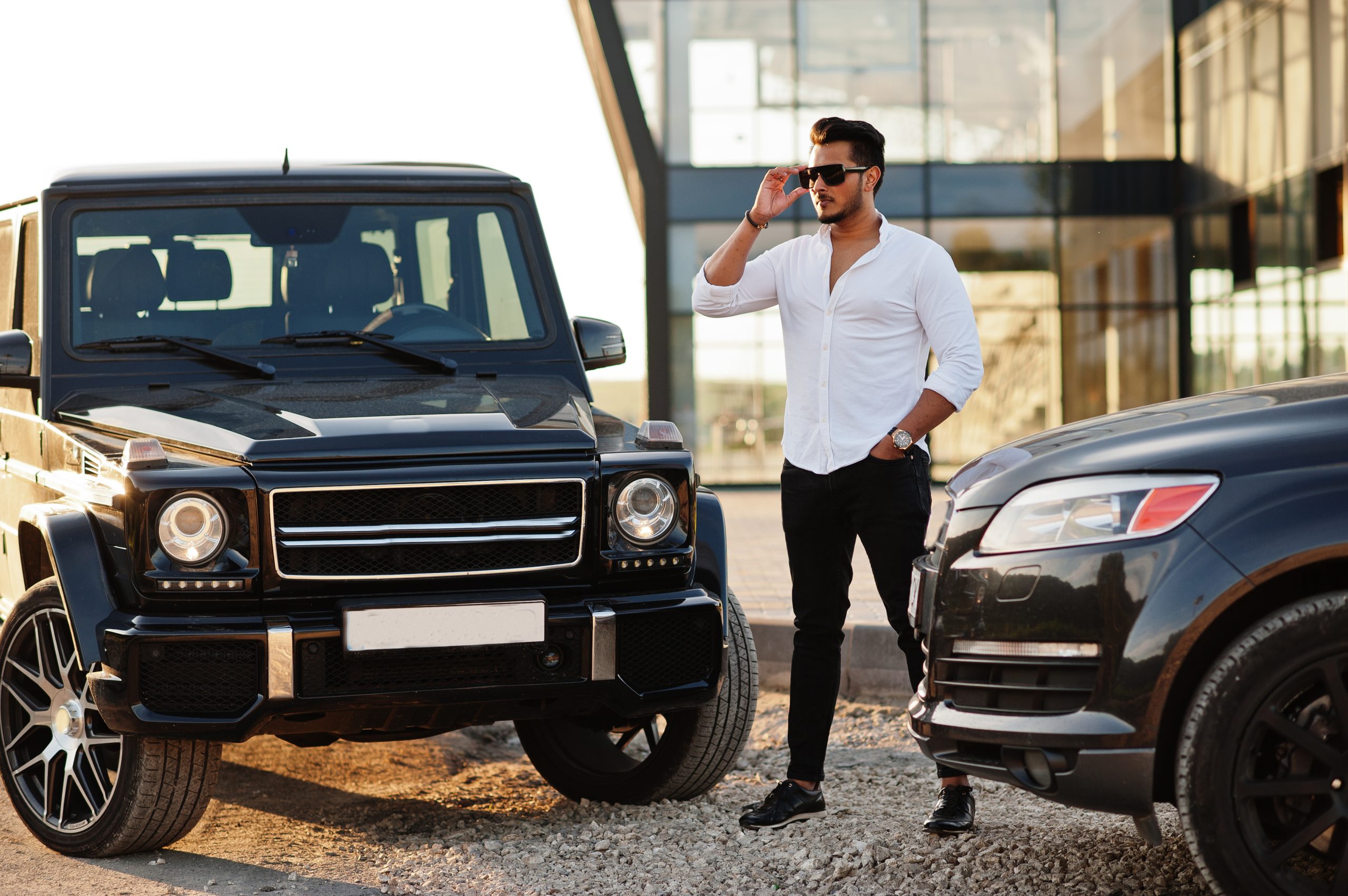 solid asian man white shirt sunglasses posed near black mafia suv cars scaled Парфюмерия Рени (Reni)